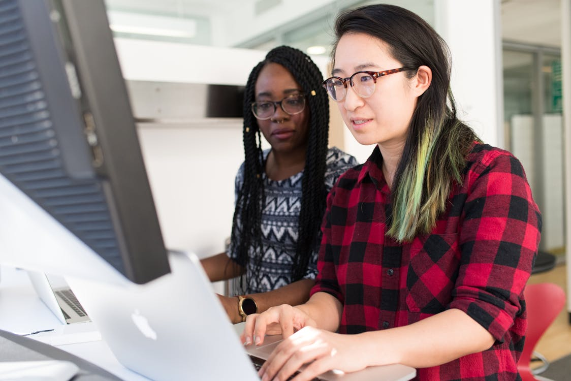 two women sitting together at work.